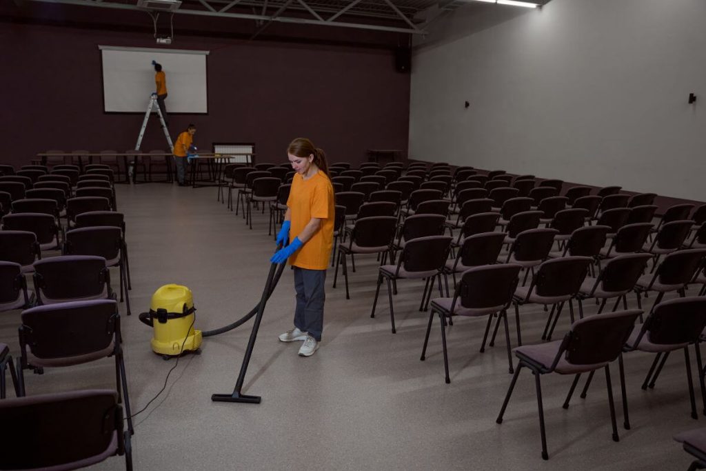 Cleaning staff vacuuming an event space during post-event cleanup