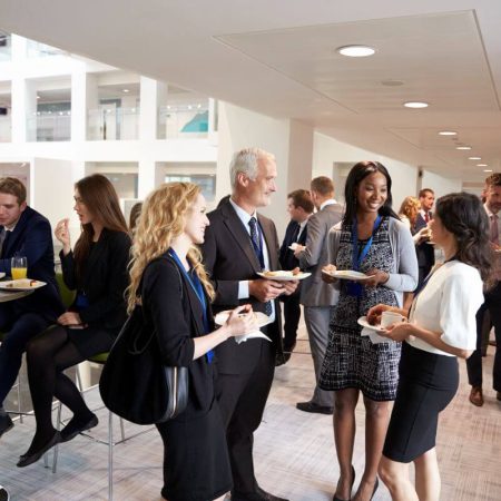 Conference attendees networking in a venue space requiring cleaning services