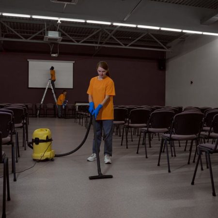 Professional cleaners preparing an event hall with vacuum and cleaning tools