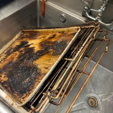 cleaning an oven in a commercial kitchen