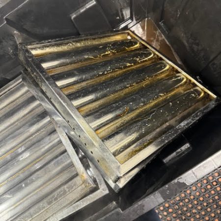 cleaning a grill in a commercial kitchen