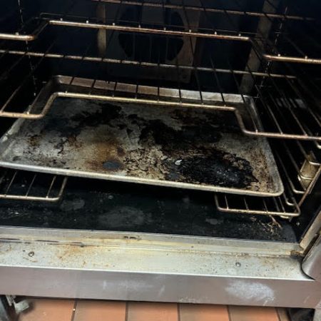 cleaning an oven in a commercial kitchen