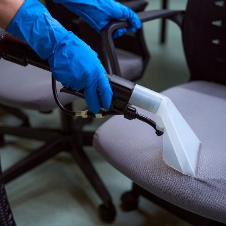 Technician performing commercial upholstery cleaning with a professional extractor